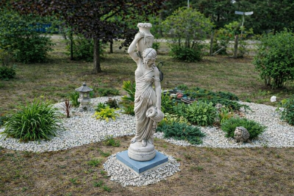 puutarhapatsas kivipohjalla pihan keskellä, ympärillä kasveja ja koristekiviä